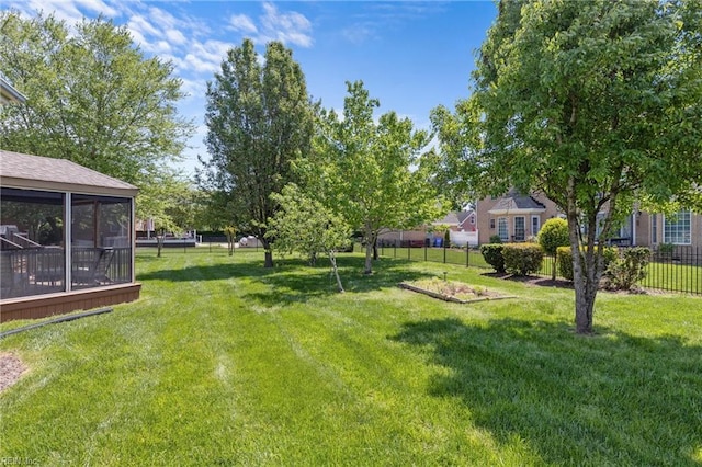 view of yard featuring fence and a sunroom