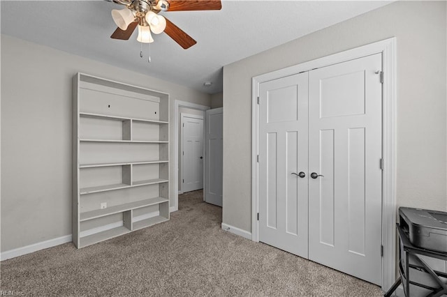unfurnished bedroom with baseboards, a ceiling fan, a closet, and carpet
