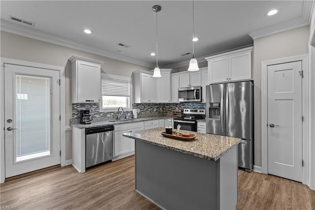 kitchen featuring crown molding, a sink, stainless steel appliances, and visible vents
