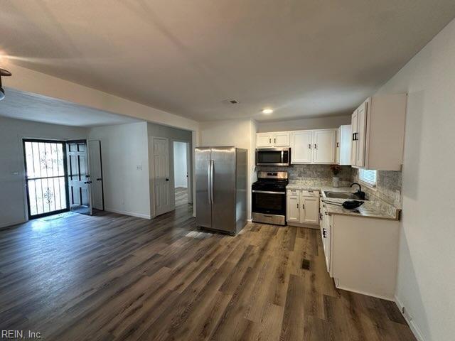 407 Wilson Ct, Suffolk, VA 23434 - kitchen featuring stainless steel appliances, white cabinets, backsplash, dark wood-style flooring, and a sink