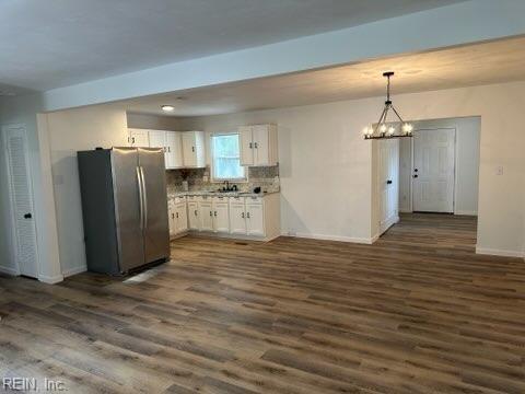 407 Wilson Ct, Suffolk, VA 23434 - kitchen with freestanding refrigerator, white cabinets, dark wood-style flooring, baseboards, and a notable chandelier