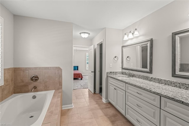 full bath featuring a bath, tile patterned flooring, vanity, and ensuite bathroom