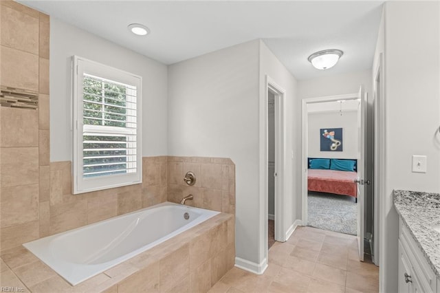 bathroom with vanity, a bath, tile patterned floors, baseboards, and ensuite bathroom