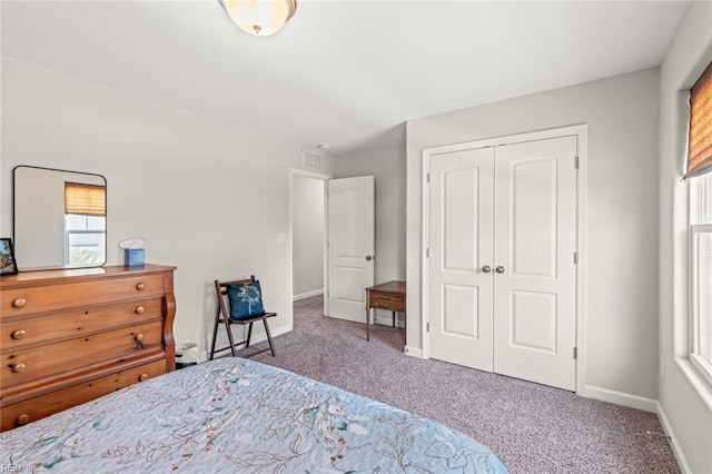 bedroom featuring baseboards, visible vents, a closet, and carpet