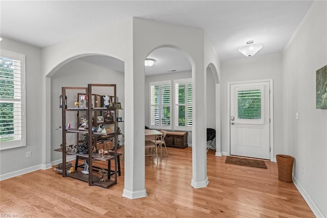 entrance foyer with a wealth of natural light, light wood-style floors, and baseboards
