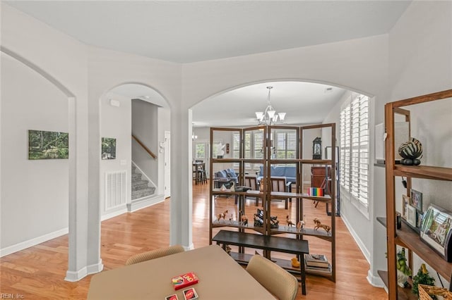 interior space featuring a chandelier, stairway, arched walkways, and a healthy amount of sunlight