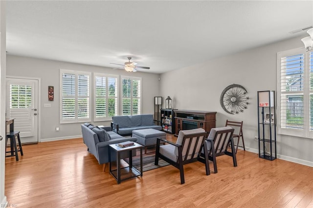 living area with light wood finished floors, ceiling fan, baseboards, and visible vents