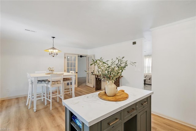 kitchen with light countertops, an inviting chandelier, visible vents, and light wood-style floors