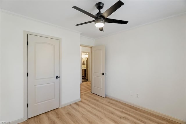 unfurnished bedroom featuring ornamental molding, ceiling fan, baseboards, and light wood-type flooring