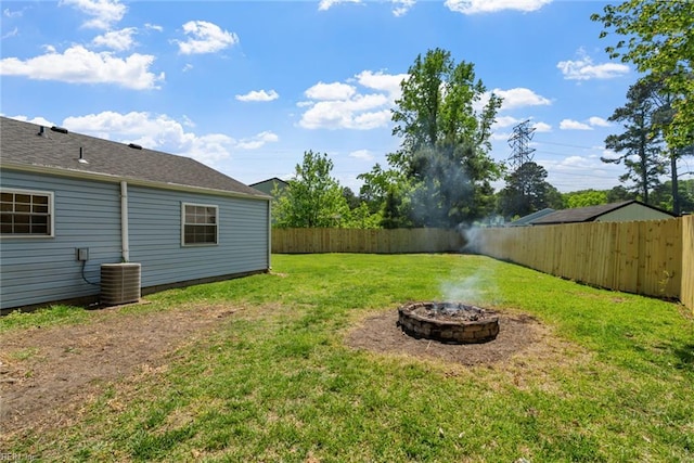 view of yard with a fire pit, a fenced backyard, and cooling unit