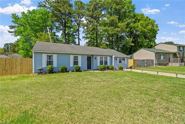ranch-style house featuring fence and a front yard