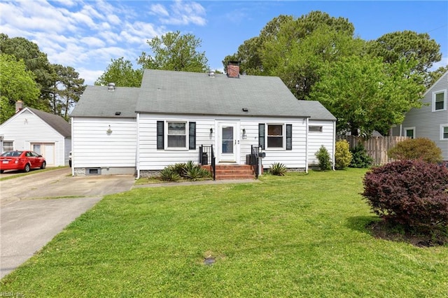 rear view of house featuring fence, a chimney, a yard, and concrete driveway