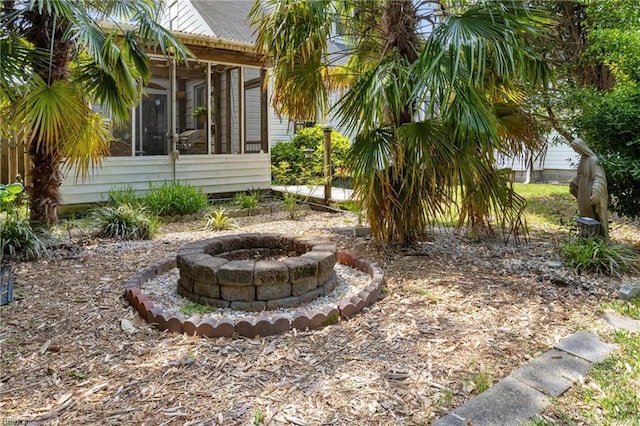 view of yard with an outdoor fire pit and a sunroom