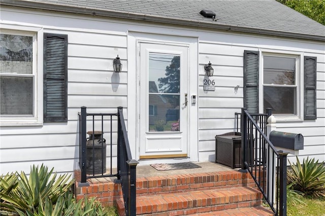 doorway to property with a shingled roof