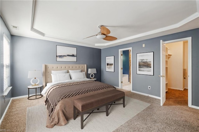 bedroom featuring visible vents, a tray ceiling, baseboards, carpet, and a spacious closet