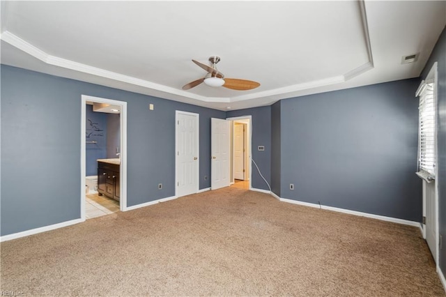 unfurnished bedroom featuring visible vents, a tray ceiling, and carpet floors