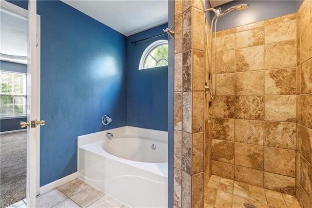 bathroom with a stall shower, a bath, and baseboards