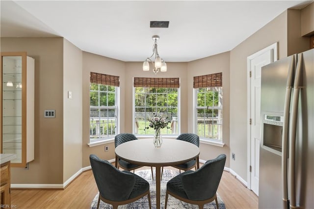dining area with baseboards, visible vents, and light wood-style floors