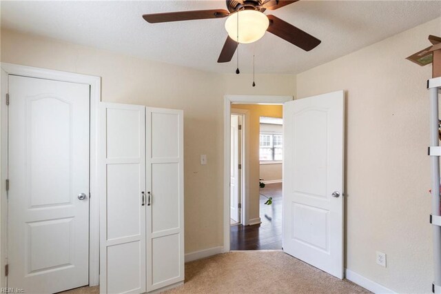 unfurnished bedroom with carpet, a ceiling fan, and baseboards