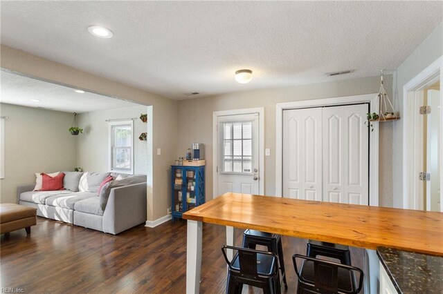 dining room with recessed lighting, baseboards, visible vents, a textured ceiling, and dark wood-type flooring