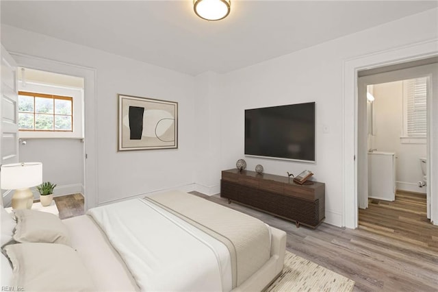 bedroom featuring wood finished floors and baseboards