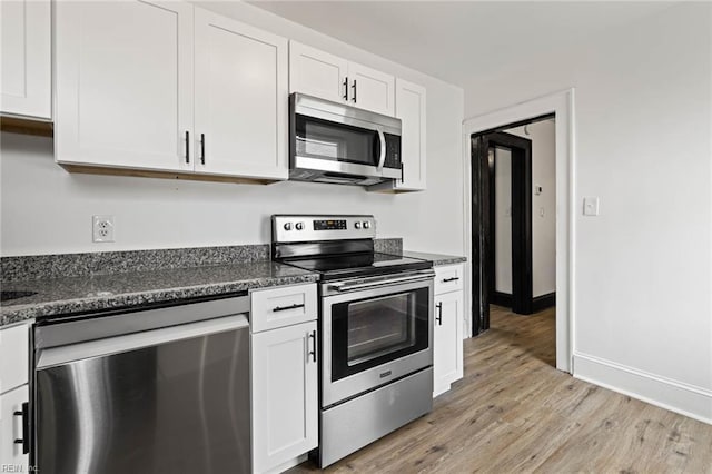 kitchen featuring stainless steel appliances, light wood-type flooring, white cabinets, and baseboards