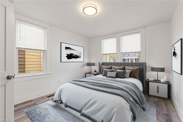 bedroom with wood finished floors, visible vents, and baseboards