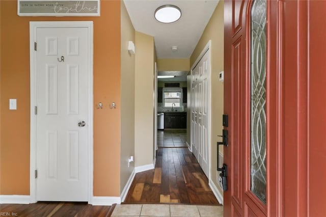 interior space with a sink, baseboards, and wood-type flooring
