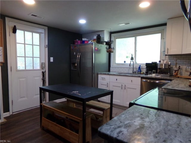 kitchen with a sink, visible vents, appliances with stainless steel finishes, and white cabinetry
