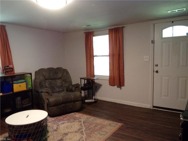living room featuring visible vents, dark wood-style floors, and baseboards