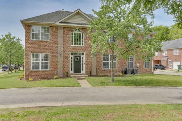 view of front of property featuring brick siding, a front lawn, and central air condition unit