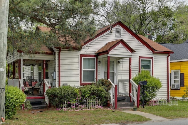 bungalow-style home featuring a front lawn and roof with shingles