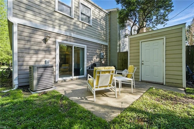 view of patio featuring an outdoor structure, central AC, and a shed