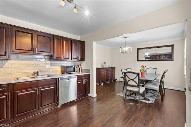 kitchen with appliances with stainless steel finishes, light countertops, decorative backsplash, and a sink