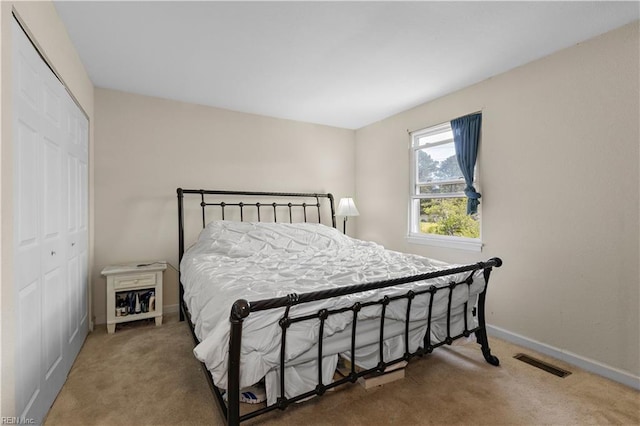 bedroom with baseboards, visible vents, carpet, and a closet