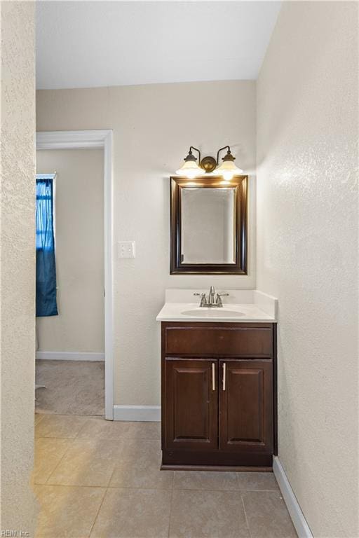 bathroom featuring baseboards, tile patterned flooring, and vanity