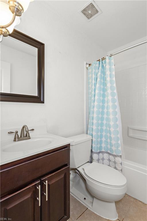 bathroom with vanity, shower / bath combination with curtain, tile patterned floors, toilet, and visible vents