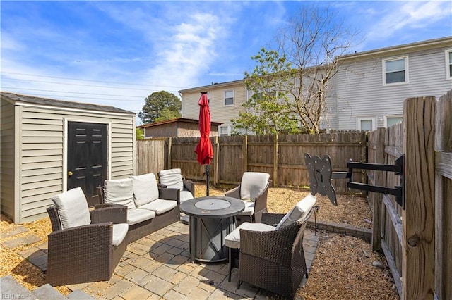view of patio with an outdoor structure, outdoor lounge area, a storage unit, and a fenced backyard