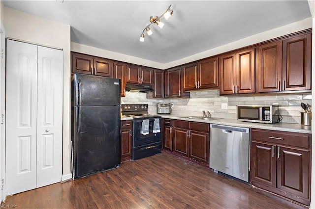 kitchen featuring dark wood-style flooring, under cabinet range hood, black appliances, backsplash, and light countertops