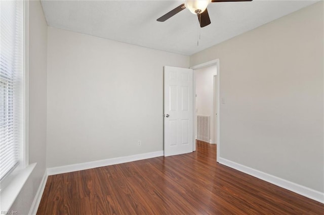 spare room featuring baseboards, visible vents, wood finished floors, and a ceiling fan