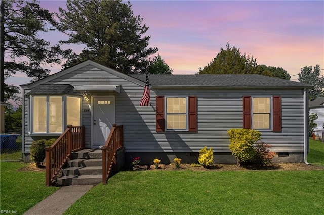 view of front of property featuring fence, a yard, and crawl space