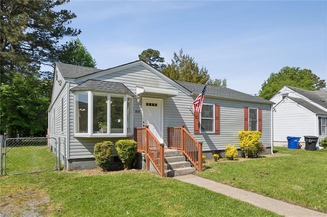 bungalow-style house with fence, a front yard, and a shingled roof