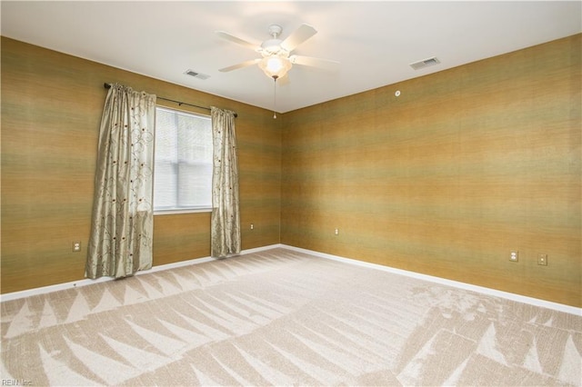 carpeted empty room featuring visible vents, ceiling fan, and baseboards