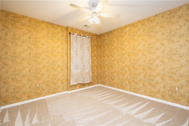 carpeted empty room with ceiling fan, baseboards, and visible vents