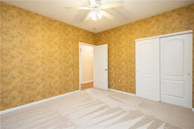unfurnished bedroom featuring baseboards, a ceiling fan, carpet floors, and a closet