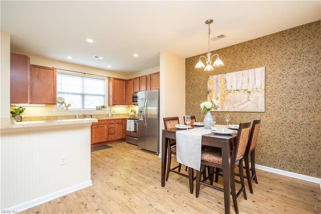 kitchen with a chandelier, visible vents, light wood-style floors, and appliances with stainless steel finishes