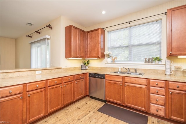 kitchen featuring light wood-style flooring, a sink, light countertops, dishwasher, and brown cabinetry