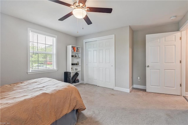 carpeted bedroom featuring baseboards, a ceiling fan, and a closet