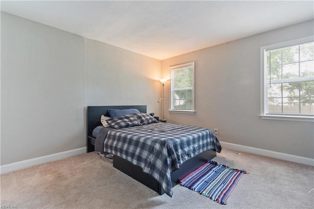 bedroom featuring carpet floors, baseboards, and multiple windows