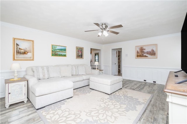 living room featuring crown molding, a ceiling fan, and wood finished floors